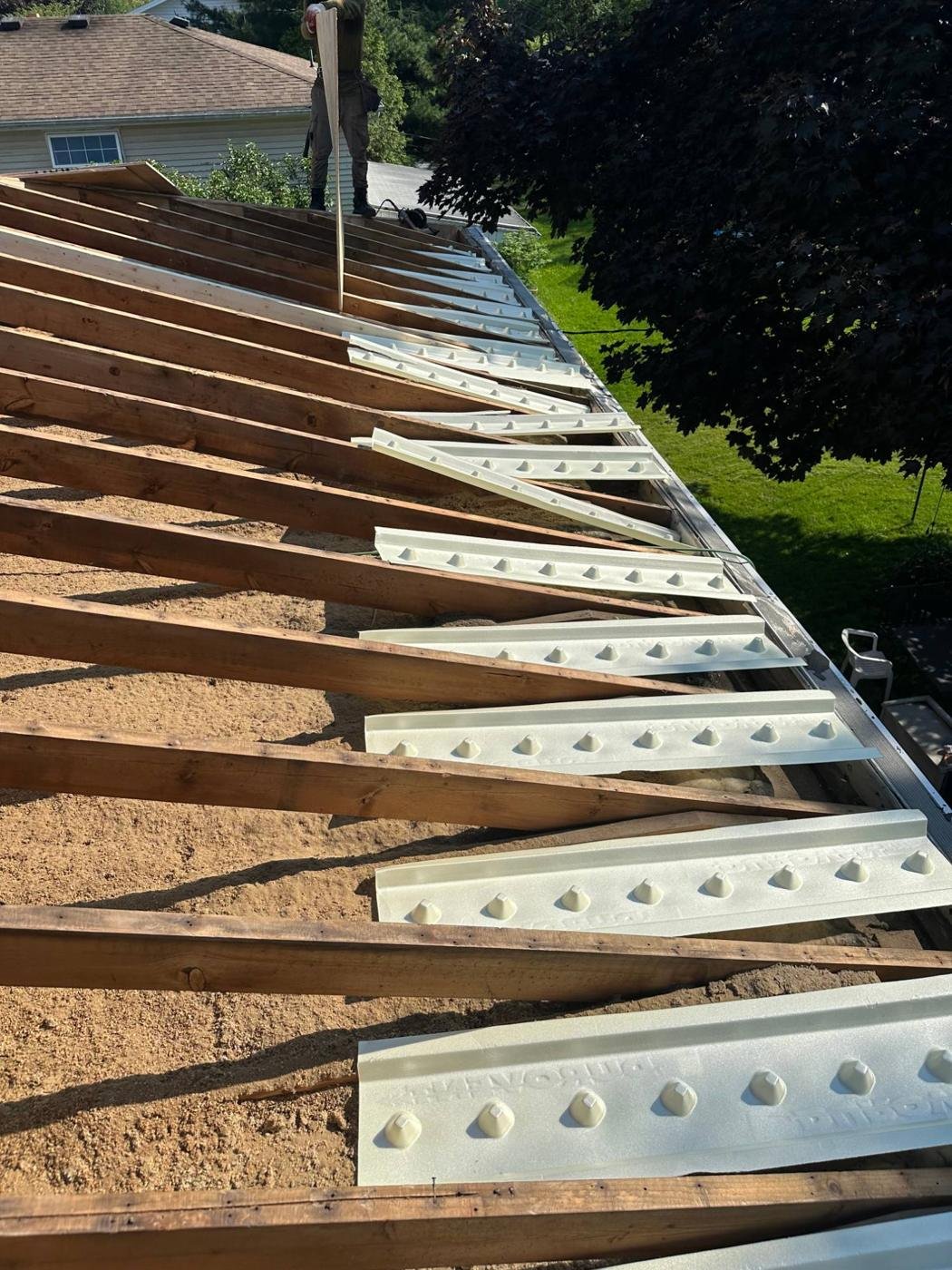 Roof rafters with new ventilation baffles during a tear-off